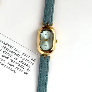 Detailed close-up view of women's vintage oval quartz watch featuring blue leather strap.