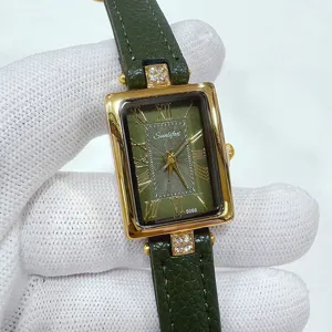 Primer plano detallado de un reloj vintage rectangular de cuero verde con números romanos.