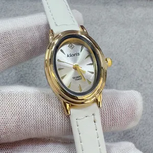 Detail van kloris gouden ovale quartz horloge met witte lederen band en zilveren wijzerplaat.