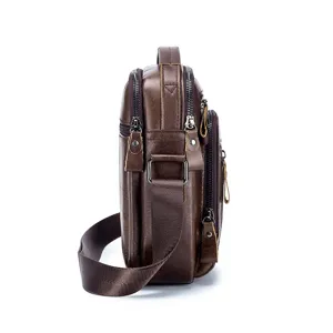 Side detail view of brown genuine leather men's small messenger bag with multi zipper compartments.