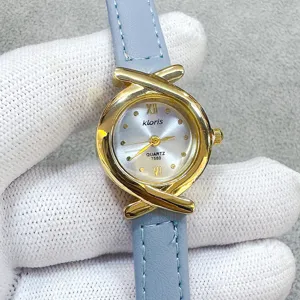 Kloris women quartz watch with light blue leather strap and vintage gold cross dial design.