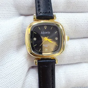 Close-up detail view of women quartz watch with gold square case and black leather strap
