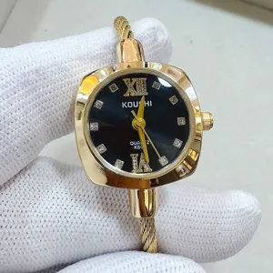 Primo piano dettagliato di orologio al quarzo dorato con quadrante nero e bracciale a cavo.