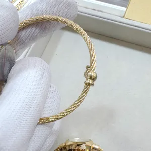 Orologio da polso da donna in acciaio dorato con cinturino intrecciato e quadrante rotondo.