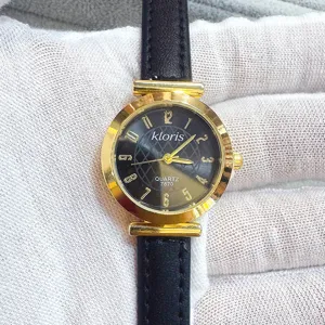 Elegant women quartz watch with black leather strap, gold round case and clear numbers dial.
