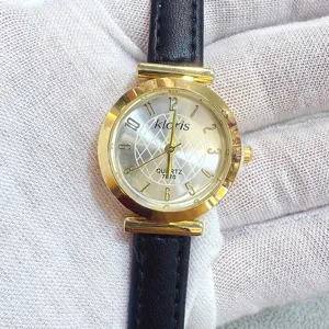 Kloris women quartz watch with round gold case, elegant black leather strap and clear arabic numerals.