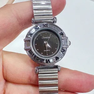 Detailweergave dames quartz horloge met vintage metalen bamboe expansieband romeinse cijfers.