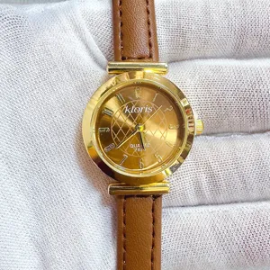 Women's quartz watch with brown leather strap and gold round dial, minimalist numerical markers.