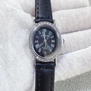 Kloris women quartz watch detail view, elegant oval rhinestone dial with black leather strap.
