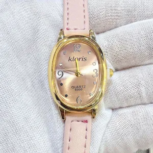 Kloris minimalistische ovale Quarzuhr Detailansicht mit rosa Lederarmband und Zifferblatt.