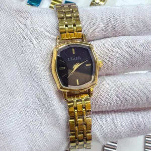 Gedetailleerde close-up van het gouden dameshorloge met een unieke polygoon kast.