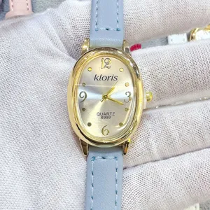 Elegante ovale Damen Quarzurmuhr mit hellblauem Lederarmband und silbernem Zifferblatt Detail.
