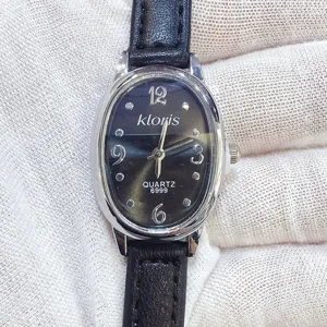 Nahaufnahme der Damen Quarzuhr mit elegantem ovalen schwarzen Zifferblatt und Lederarmband.