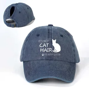 Detailed view of the washed denim ponytail baseball hat with cat quote print and metal buckle.