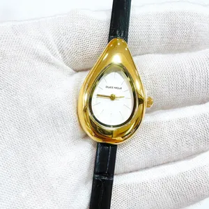 Elegante tropfenförmige Damenuhr in Gold mit schwarzem Lederarmband und weißem Zifferblatt.