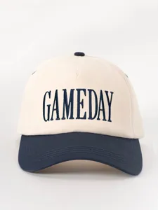 Primer plano detallado que muestra el texto bordado GAMEDAY en la corona de la gorra bicolor.