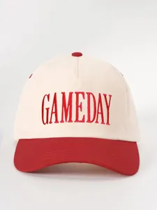 Vista detallada de la gorra de béisbol en bloques de color rojo y blanco con bordado GAMEDAY.