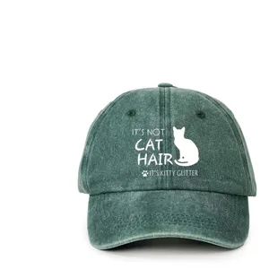 Close-up detail of the washed green baseball cap featuring a fun cat quote print.
