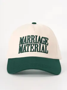 Detailed close-up of contrast color baseball cap featuring dark green embroidery text.