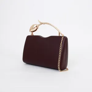 Elegant wine red evening clutch bag with gold flower handle and chain strap for women.