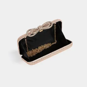 Sparkling rhinestone bow clutch bag with gold chain strap detail for women evening party.