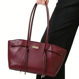 Burgundy leather tote bag detail featuring sophisticated trapezoid design and sleek hardware.