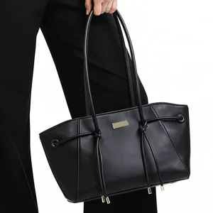 Detailed view of a chic black trapezoid tote bag with double straps and stylish side drawstrings.