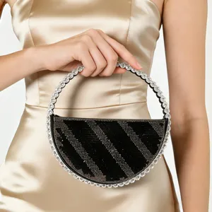 Rhinestone encrusted ring handle and black striped pattern evening handbag detail view for party.