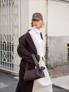 Detailed view of the dark brown leather handbag featuring a chic cloud dumpling design.