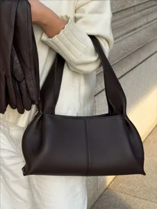 Detail shot of a dark brown leather underarm bag with long handle and chic slouchy style.