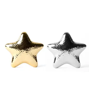 Metallic star detail, glossy shiny finish, elegant evening bag close-up texture view.