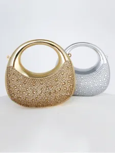 Gros plan de mini sacs de soirée lune en strass avec poignées rondes en métal brillant et éclats.