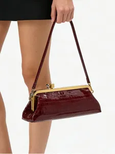 Close-up detail of the burgundy crocodile pattern baguette shoulder bag with gold frame.