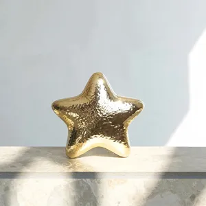 Close-up of the stylish metallic star-shaped evening clutch bag, showing glossy gold texture.