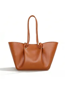 Brown leather slouchy tote bag detail showing knotted handles and metal ring accents.