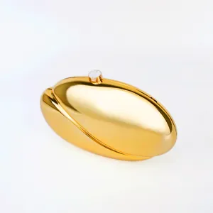 Gold metallic hard shell clutch detail, sleek oval bean shape design, luxury evening bag.