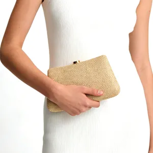 Vue détaillée de la pochette tissée dorée montrant le fermoir métallique et la texture.