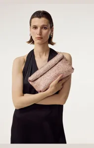 Gros plan détaillé de la pochette enveloppe scintillante en strass roses style mode.