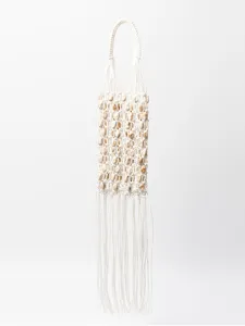 Handmade woven macrame beaded fringe handbag detail shot, bohemian beach resort style.