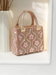 Detail shot of sparkling pink rhinestone evening handbag with elegant floral crystal details.