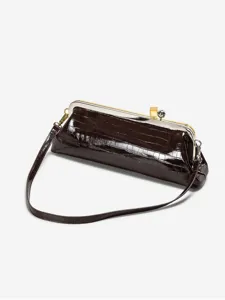 Close-up detail of dark brown crocodile embossed long baguette shoulder bag with clasp frame.