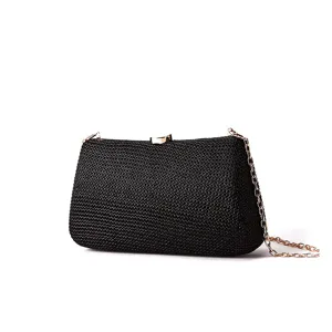 Vue détaillée de l'élégante pochette de soirée noire tissée avec chaîne et fermoir dorés chic.