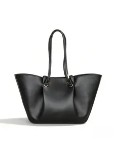 Black leather tote bag detail showcasing pleated cloud design and elegant handle craftsmanship.