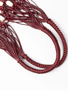 Close-up detail shot of burgundy waxed cord woven bag handle featuring intricate bohemian design.