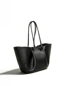 Close-up detail of the black leather tote bag showing pleated front design and metal ring.