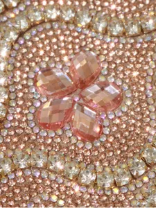 Detailed view of sparkly rhinestone evening bag with pink crystal flower motif for women parties.