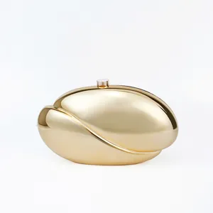 Detail view of the sleek gold metal acrylic wave clutch bag, showing smooth curved surface.