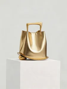 Luxury metallic gold bucket bag with unique sculptural handle and base for modern women.