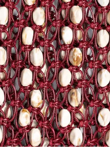 Close-up detail of dark red wax rope woven bag with mottled beads, handmade texture net.