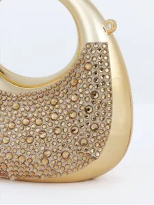 Gros plan d'un superbe sac de soirée croissant doré en strass avec des cristaux étincelants.